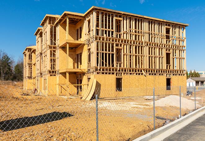 a close-up of temporary chain link fences enclosing a construction site, signaling progress in the project's development in Roxbury Crossing, MA